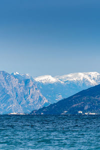 Scenic view of snowcapped mountains against clear blue sky