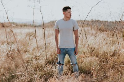 Full length of young man looking away on field