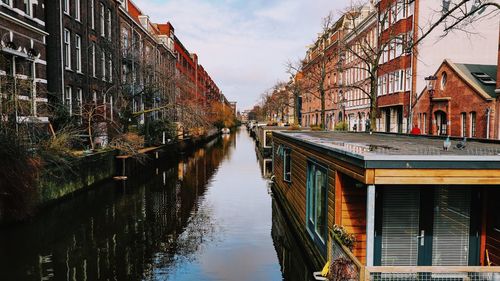 Canal amidst buildings against sky