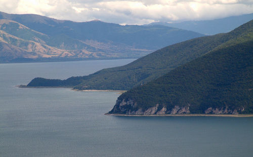 Scenic view of sea and mountains against sky