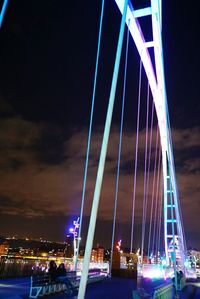 Illuminated bridge over river at night