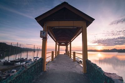 Pier over sea against sky during sunset