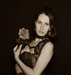 Portrait of a beautiful young woman over black background