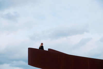 Low angle view of a young woman standing on an empty bridge