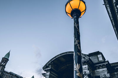 Low angle view of street light and buildings against sky