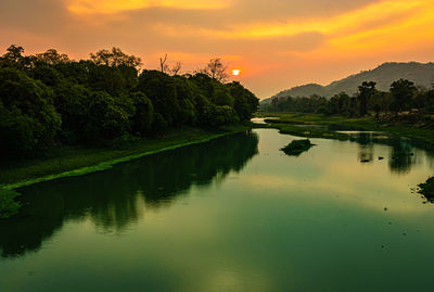 Scenic view of lake against sky at sunset