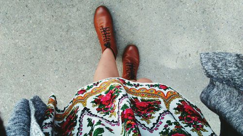 Low section of woman standing on footpath