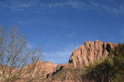 Low angle view of rocks against blue sky