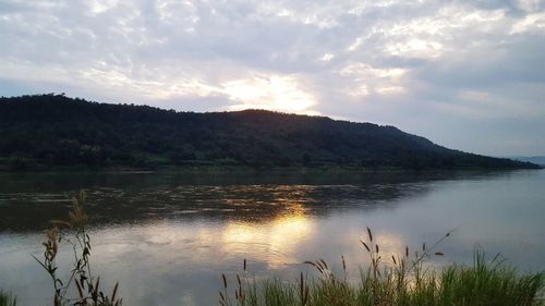 Scenic view of lake by mountains against sky