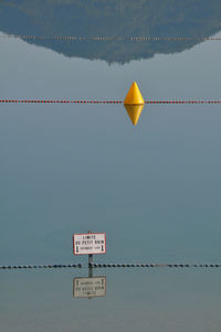 Information sign on rope against clear sky