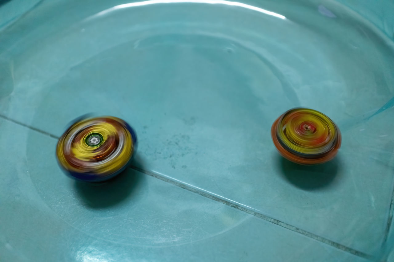 HIGH ANGLE VIEW OF MULTI COLORED WATER ON TABLE