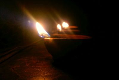 Close-up of lit candle in dark room