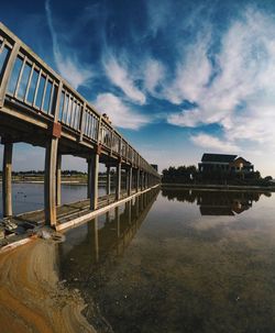 Bridge over river against cloudy sky