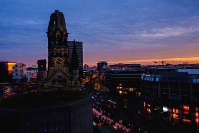 High angle view of city lit up at sunset