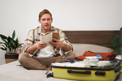 Portrait of smiling friends sitting on sofa at home