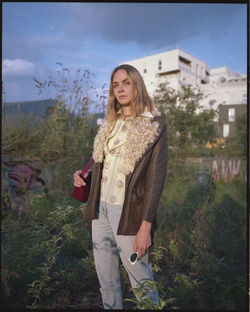 Portrait of woman standing against plants