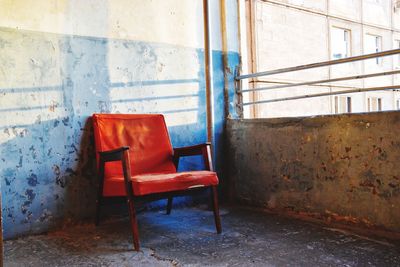 Empty chairs against wall in abandoned building