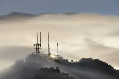 Low angle view of communications tower against sky during sunset