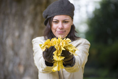 Close-up of young woman with yellow flower