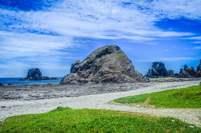 Scenic view of rocks on beach against sky