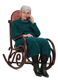 Woman sitting on chair against white background