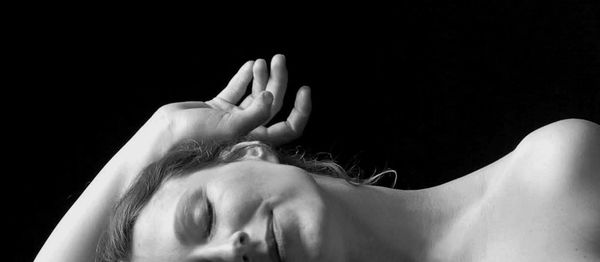 Close-up of woman sleeping against black background