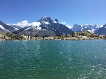 Scenic view of sea and mountains against blue sky