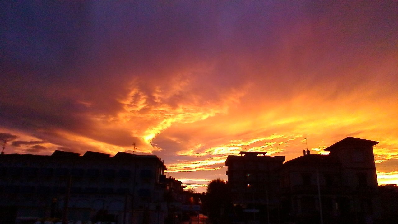 SILHOUETTE HOUSES AGAINST SKY AT SUNSET