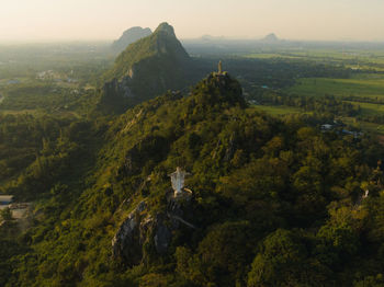 An aerial view of christ the redeemer and buddha on the mountain stands prominently