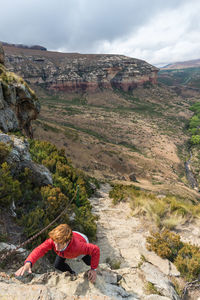 Tourist climbing cliff at golden gate highlands national park