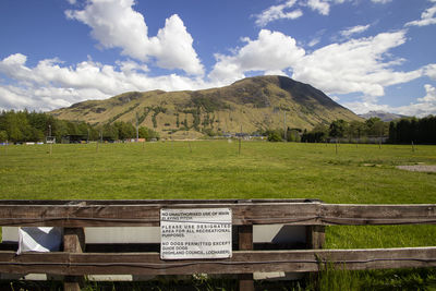 Information sign on field against sky