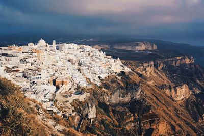 Aerial view of houses on mountain against sky