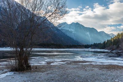 Scenic view of lake by snowcapped mountains against sky