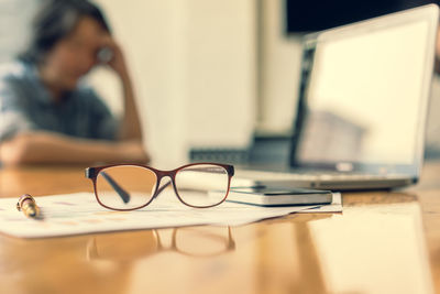 Close-up of woman using laptop on table