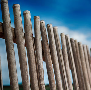 Low angle view of wooden post against blue sky