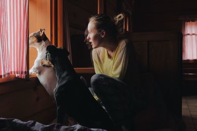 Woman sitting with dogs at home