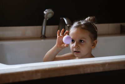 Child holding bath bomb. relaxing hygiene procedure for kids. aromatherapy and fun at home. happy