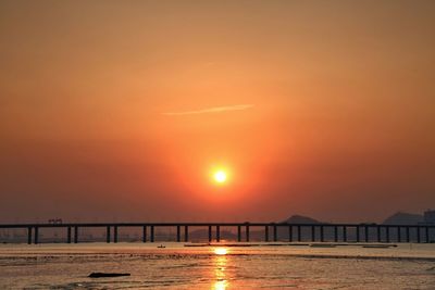 Bridge over river at sunset