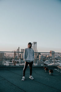 Full length of man standing on city against clear sky