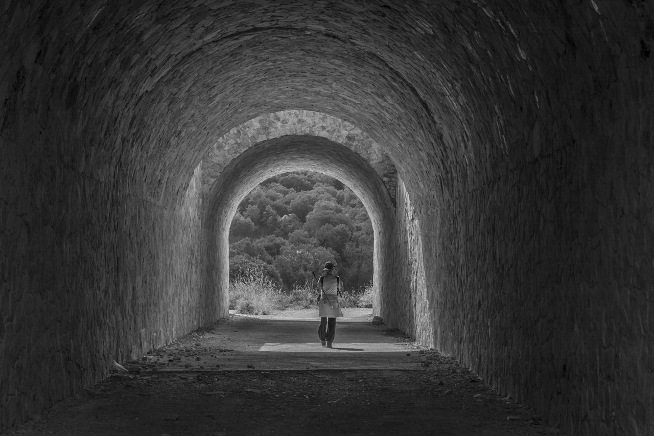 arch, tunnel, real people, built structure, light at the end of the tunnel, one person, outdoors, architecture, men, day, people