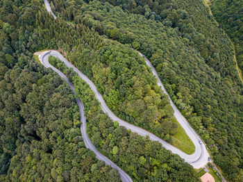 Winding road from high mountain pass, in summer time. aerial view by drone. romania