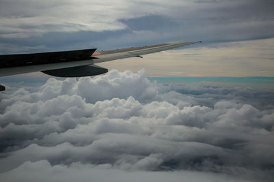 Airplane flying over clouds in sky