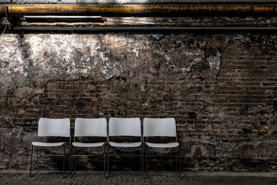 Empty chair against wall