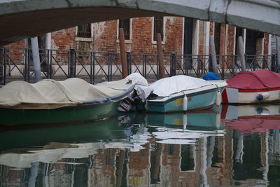 Boats moored in lake against buildings in city