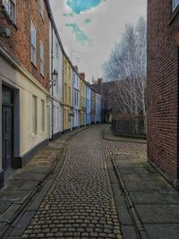 Empty footpath amidst buildings in city