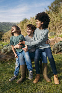 Happy family sitting on a bench in a garden