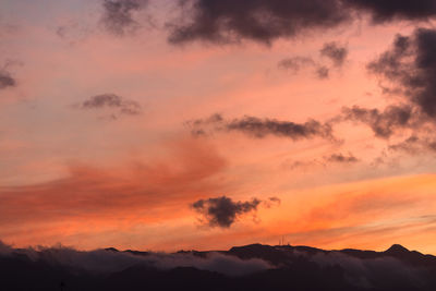 Low angle view of silhouette mountains against romantic sky