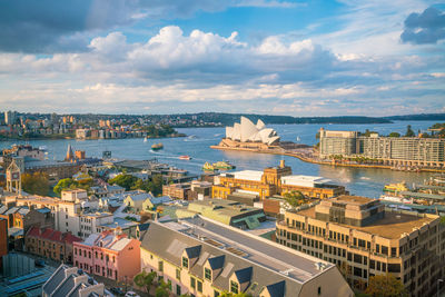 High angle view of city buildings against cloudy sky