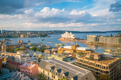 High angle view of city buildings against cloudy sky