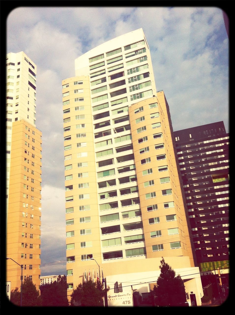 building exterior, transfer print, architecture, built structure, sky, auto post production filter, low angle view, cloud - sky, city, cloud, building, cloudy, tall - high, modern, tower, residential building, skyscraper, outdoors, day, no people